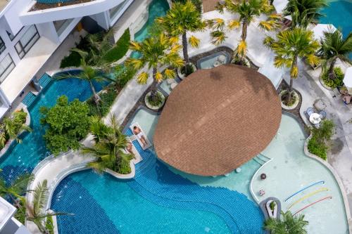 an overhead view of a pool at a resort with palm trees at Wyndham Garden Naithon Phuket in Nai Thon Beach