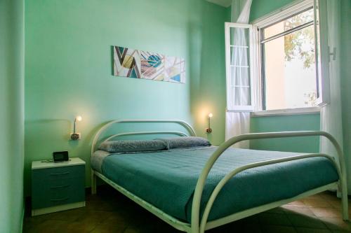 a bedroom with a bed with blue walls and a window at Welcome to our Home Villetta Baia Verde Gallipoli in Baia Verde