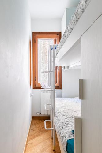 a small bedroom with a bunk bed and a ladder at Casa MammaMarisa in Murano