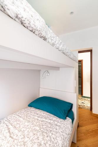 a white bedroom with a bed and a staircase at Casa MammaMarisa in Murano