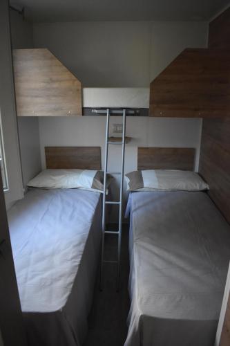 two bunk beds in a room with a ladder at OasiHome in SantʼAndrea
