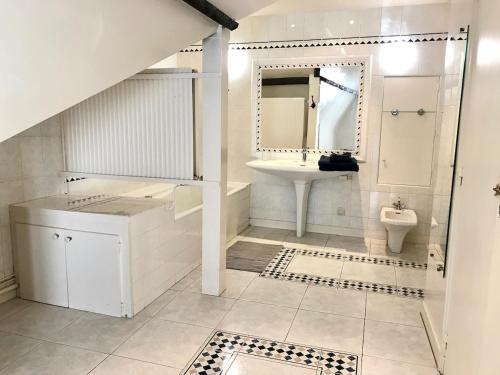 une salle de bain blanche avec un lavabo et des toilettes dans l'établissement Grand appartement de charme vieux Chinon 11 personnes, à Chinon