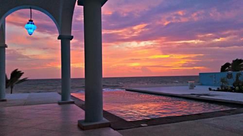 a sunset at the beach with a swimming pool at Villa Star of the Sea in Barra de Navidad