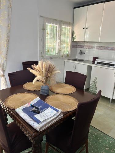 a kitchen with a wooden table with chairs and a table sidx sidx sidx at Casita Rural La Rosa de la Huerta con chimenea interior in Monachil