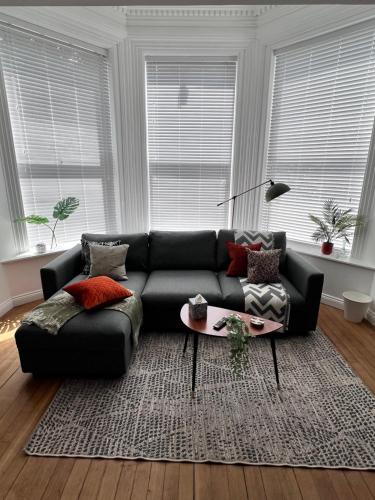 a living room with a black couch and a table at On The Avenue Apt 1 in Nottingham