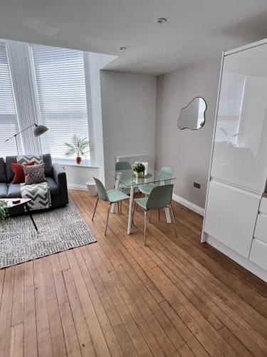 a living room with a glass table and chairs at On The Avenue Apt 1 in Nottingham