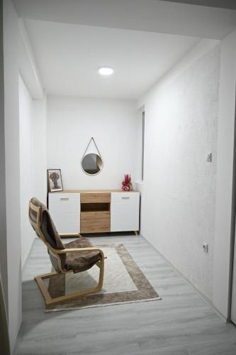a living room with a chair and a desk at Apartmani P7 in Dračevo