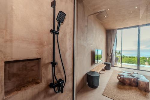 a room with a fireplace and a shower with a hair dryer at inchantreedoolay huahin in Pran Buri