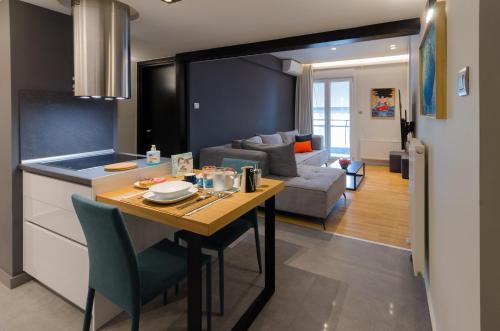 a kitchen and living room with a table and a couch at Above & Beyond Volos City Center Luxury Redefined in Volos