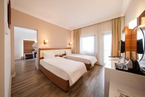 a hotel room with two beds and a television at Iris Hotel & Spa in Canakkale