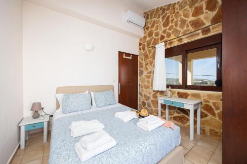 a bedroom with a bed and a table and a window at Villa Pasiphae 1 in Stalos