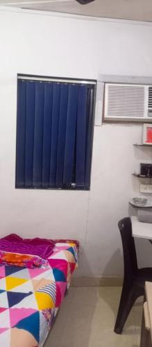 a room with a bed and a window and a desk at SAM PALACE DANDA Village in Mumbai