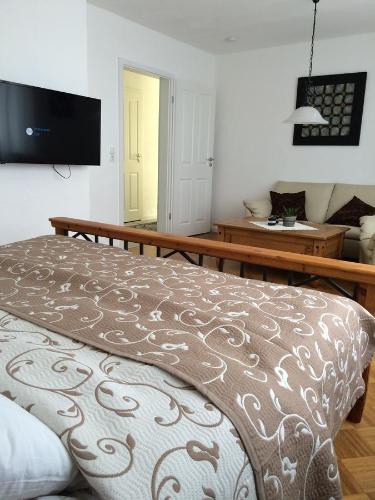 Schlafzimmer mit einem Bett und einem TV an der Wand in der Unterkunft Ferienhaus Mosel in Löf