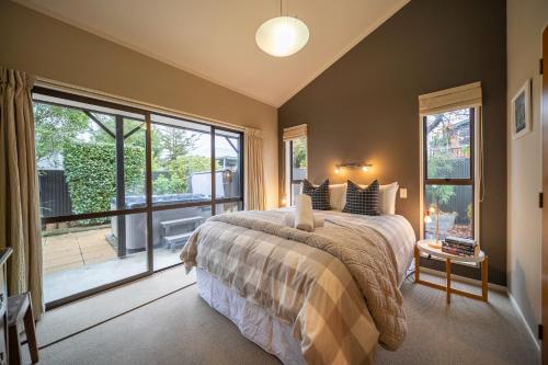 una camera da letto con un letto e una grande finestra di Townhouse Retreat - Te Anau Getaway a Te Anau