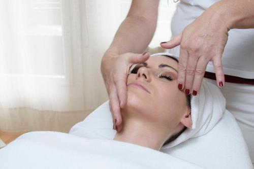 a woman getting her face massage at a spa at Aktiv & Spa Hotel Alpenrose in Schruns-Tschagguns