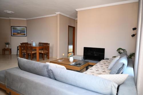 a living room with a couch and a table at Amos Apartment in Sarandë