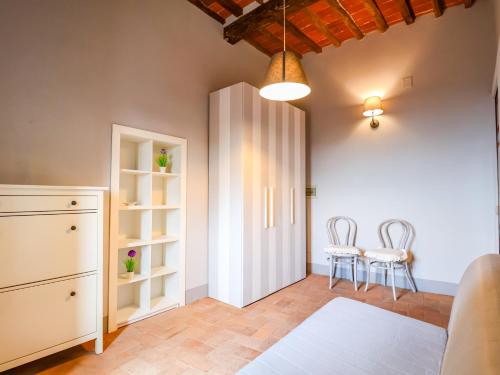 a room with a white cabinet and two chairs at Tuscan Nest - in Montecatini Alto in Montecatini Alto