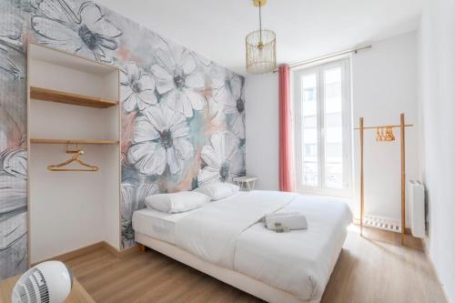 - une chambre avec un lit blanc et un mur fleuri dans l'établissement T3 spacieux et lumineux, à Marseille