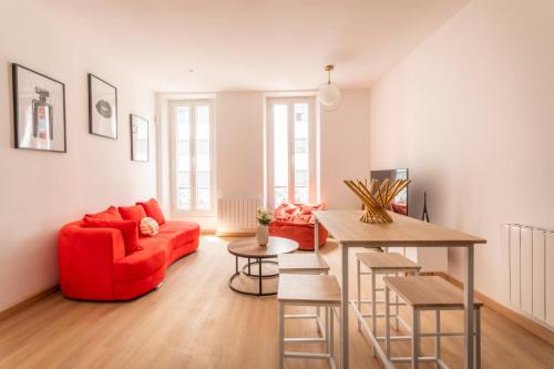 un salon avec un canapé rouge et une table dans l'établissement T3 spacieux et lumineux, à Marseille