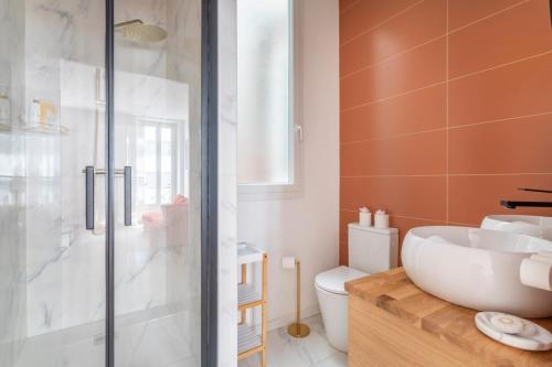 une salle de bain avec un lavabo, des toilettes et une douche dans l'établissement T3 spacieux et lumineux, à Marseille