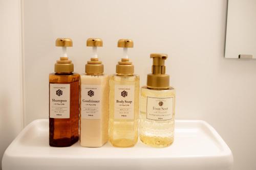 four bottles of essential oils sitting on a sink at Osaka U-Shuku in Osaka