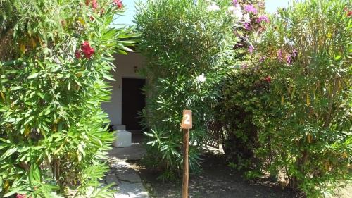 a garden with a sign in the middle of some bushes at Hotel Rurale Orti di Nora & SPA in Santa Margherita di Pula