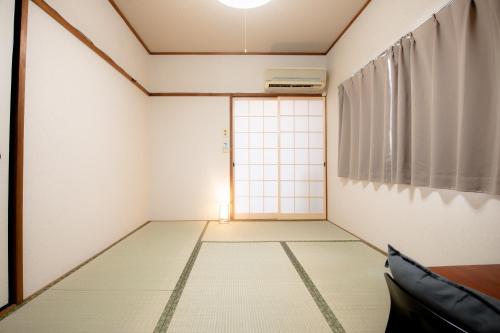 an empty room with a door and a window at Osaka U-Shuku in Osaka
