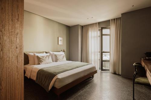 a hotel room with a bed and a window at Perianth Hotel, a Member of Design Hotels in Athens