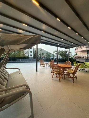 a patio with a table and chairs and an umbrella at Beach Suites - İçmeler in Icmeler