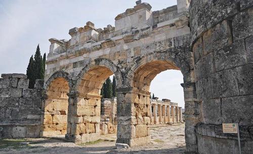 an old stone building with arches in a field at PRETTY HOUSE in Pamukkale