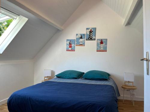 une chambre avec un lit avec des draps bleus et une fenêtre dans l'établissement La maison des dunes de Kerambigorn, à Fouesnant