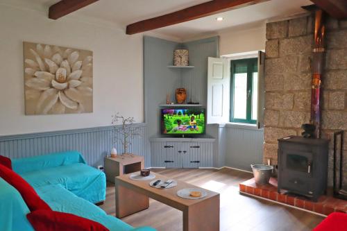 a living room with a blue couch and a tv at Bed and breakfast EXCLUSIVE & Luxury Traditional Portuguese Farmhouse
