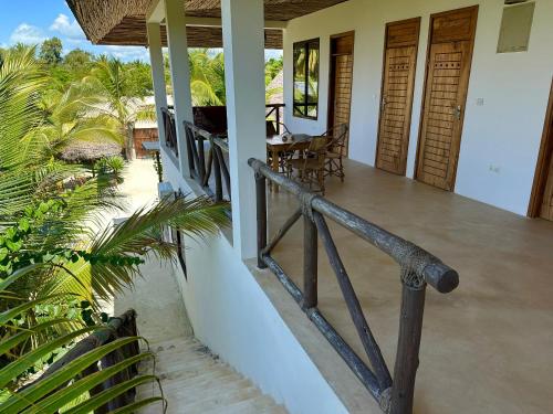 a balcony of a house with a table and chairs at Sand Beach Boutique Apartments in Bwejuu