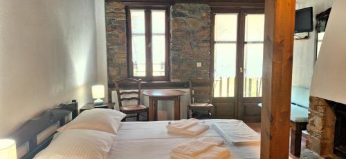 a bedroom with a bed with towels on it at Kastania Gi in Palaios Panteleimon