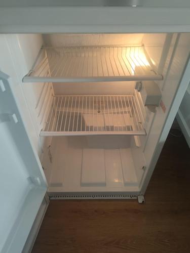 an empty refrigerator with its door open in a room at Monteurzimmer Mühlheim am Main Nähe S-Bahn in Mühlheim