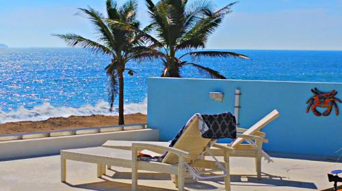 two chairs and a table on a balcony overlooking the ocean at Villa Star of the Sea in Barra de Navidad