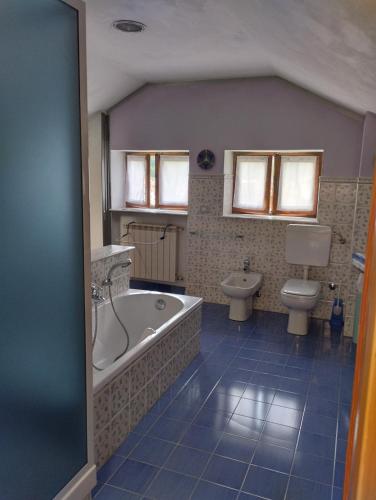 a bathroom with a tub and a toilet at Mansarda Giaveno in Giaveno