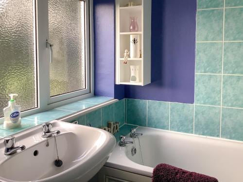 a bathroom with a white tub and a sink at New House Farm Annexe in Neenton