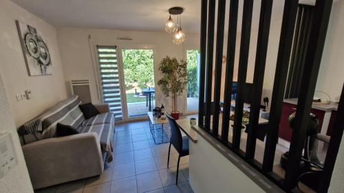 un salon avec un canapé et une table dans l'établissement Royan - APPARTEMENT en rez-de-chaussée aménagé avec ELEGANCE - jardin privatif, à Royan