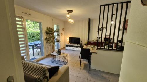 un salon avec un canapé et une table dans l'établissement Royan - APPARTEMENT en rez-de-chaussée aménagé avec ELEGANCE - jardin privatif, à Royan