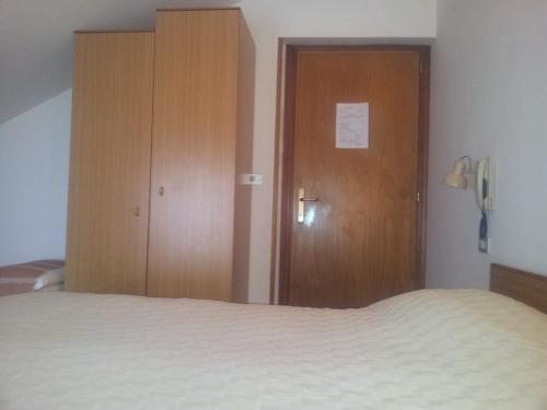 a bedroom with a bed and a wooden door at La Colombella in Montemonaco