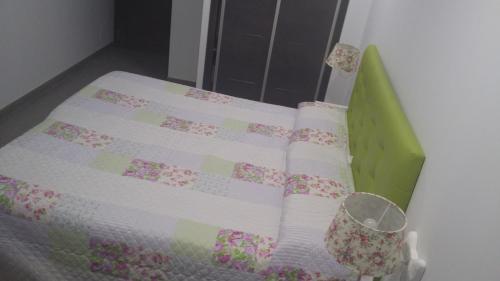 a green crib with a quilt on top of it at Hostal Boutique Bajamar in Nerja
