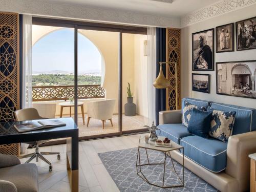 a living room with a blue couch and a balcony at Fairmont Tazi Palace Tangier in Tangier