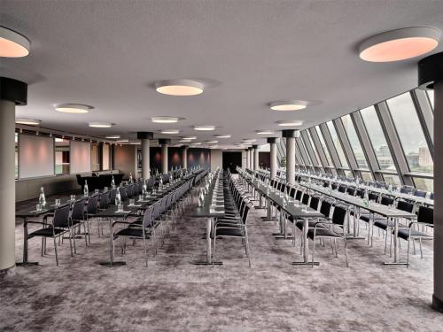 a row of tables and chairs in a room with windows at Radisson Collection Hotel, Berlin in Berlin