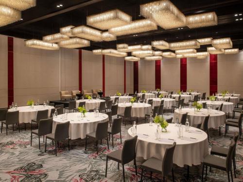 a banquet hall with white tables and chairs and chandeliers at Fairmont Tazi Palace Tangier in Tangier