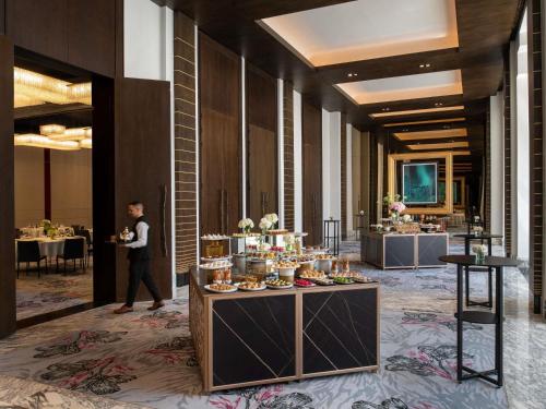 a man walking through a lobby with a buffet of food at Fairmont Tazi Palace Tangier in Tangier
