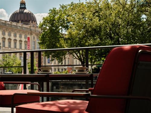 a balcony with chairs and a view of a building at Radisson Collection Hotel, Berlin in Berlin
