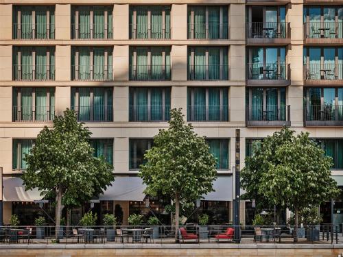 a building with tables and trees in front of it at Radisson Collection Hotel, Berlin in Berlin
