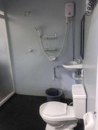 a bathroom with a white toilet and a sink at MARIA GUEST House in Maricaban