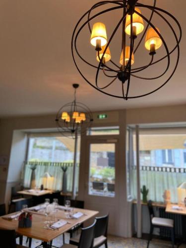 a dining room with a table and a chandelier at Auberge du Chasseur in Grosrouvre